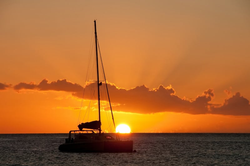 A catamaran is silhouetted by the setting sun on the island of St. Lucia in the Caribbean.
